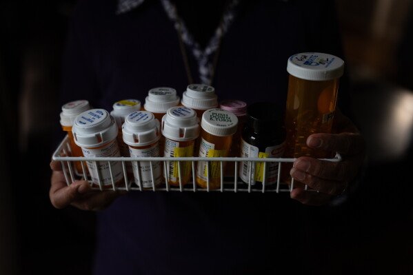 Masuma Khan, an immigrant from Bangladesh who was held at an immigration detention facility in California City the previous year, holds the medications she takes daily, in Altadena, Calif., April 21, 2026. (AP Photo/Jae C. Hong)