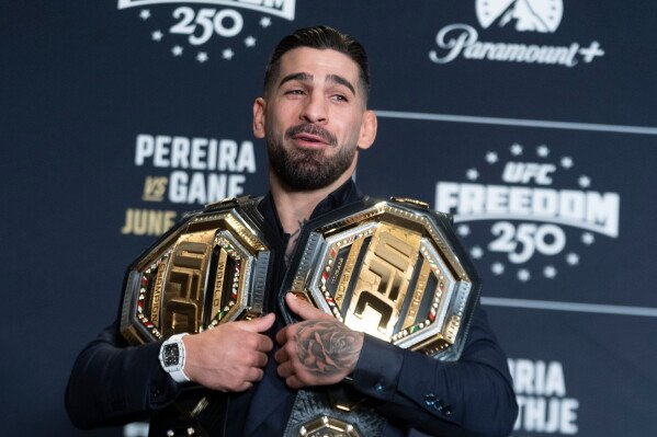 UFC lightweight champion Ilia Topuria, holds his championship belts during the UFC Freedom 250 media day, Wednesday, June 10, 2026, in Washington. (AP Photo/Manuel Balce Ceneta)