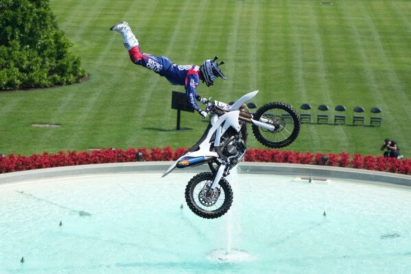 A motor sports athlete and stunt performer does a motorcycle jump ahead of the UFC Freedom 250 fights on the South Lawn of the White House, Saturday, June 13, 2026, in Washington. (AP Photo/Mark Schiefelbein, Pool)