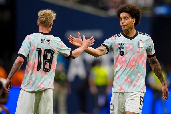 Belgium's Joaquin Seys (18) and Axel Witsel celebrate after defeating the United States in an international friendly soccer match, Saturday, March 28, 2026, in Atlanta. (AP Photo/Mike Stewart)