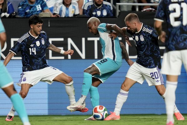 Honduras' Joseph Rosales (8) fights off Argentina midfielder Alexis Mac Allister (20) and midfielder Exequiel Palacios (14) during the second half of an international friendly soccer match Saturday, June 6, 2026, in College Station, Texas. (AP Photo/Sam Craft)