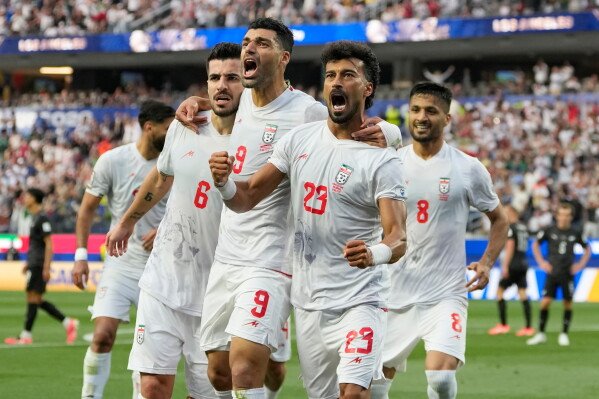 Iran's Ramin Rezaeian (23) celebrates with his teammates after scoring a goal during the World Cup Group G soccer match between Iran and New Zealand in Inglewood, Calif., near Los Angeles, Monday, June 15, 2026. (AP Photo/Andre Penner)