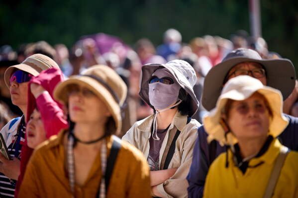 Tourists wear hats to protect themselves from the sun as they admire one of the facades of the Sagrada Familia church in Barcelona, Spain, May 28, 2026. (AP Photo/Emilio Morenatti, File)