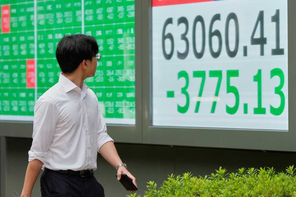 A person walks in front of an electronic stock board showing Japan's Nikkei index at a securities firm Friday, July 17, 2026, in Tokyo.
