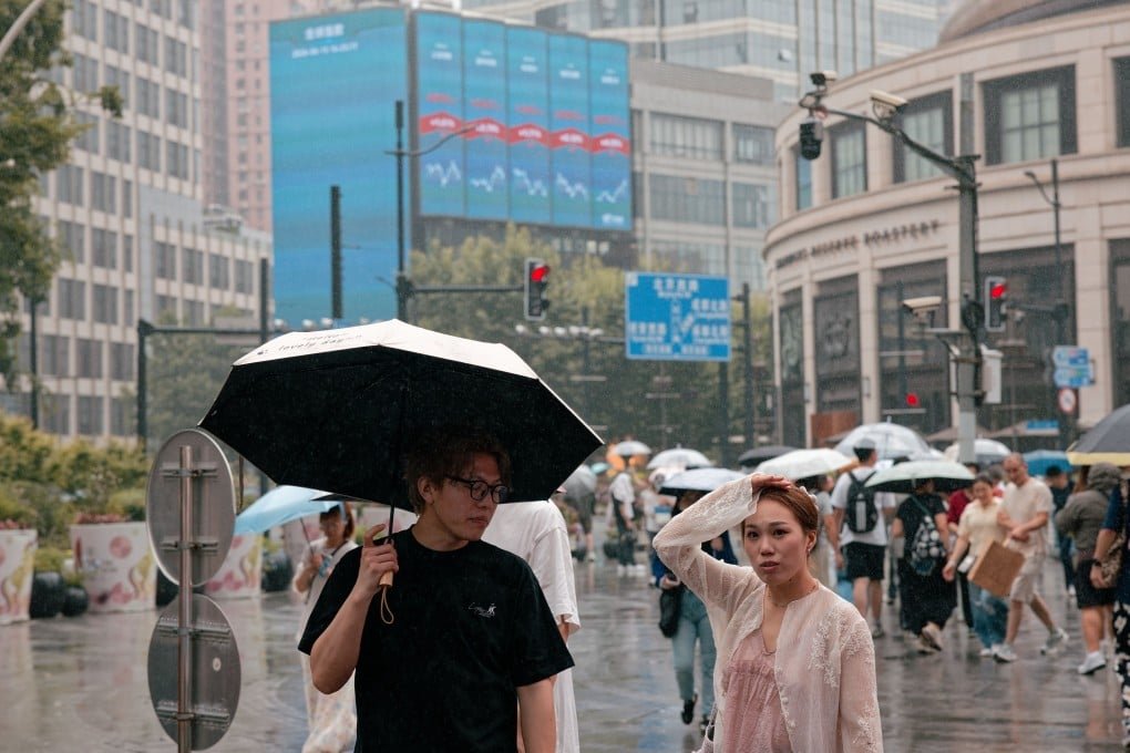 People walk on a street beneath a large screen showing the latest stock market and economic data in Shanghai, China, on June 15. Photo: EPA
