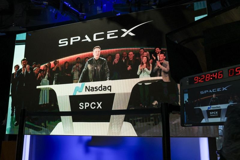 SpaceX CEO Elon Musk, displayed on a screen remotely from SpaceX headquarters in Starbase, Texas, speaks before the launch of SpaceX's initial public offering at the Nasdaq MarketSite in New York on June 12, 2026.