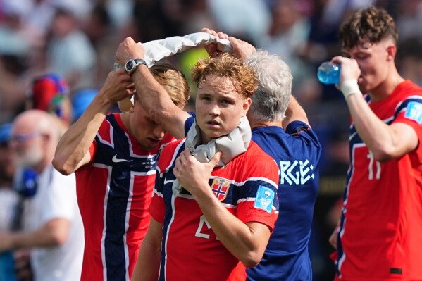 Norway's Andreas Schjelderup and others wear icepacks around their necks during an hydration break during the World Cup Group I soccer match between Norway and France in Foxborough, Mass., near Boston, Friday, June 26, 2026. (AP Photo/Martin Meissner)