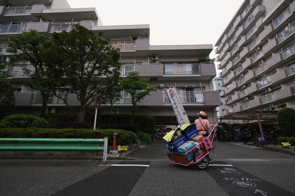 Akiko Sugaya looks for signs of customers while she peddles tofu, prepared food and beverages in a cart in Tokyo, Saturday, July 4, 2026. (AP Photo/Hiro Komae)