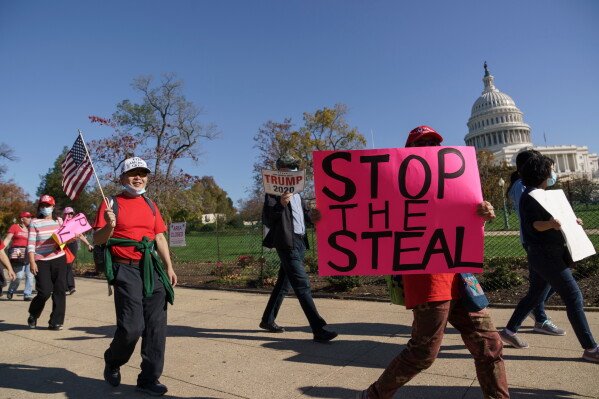 Supporters of President Donald Trump carry flags and signs as they parade past the Capitol in Washington, after news that President-elect Joe Biden had defeated the incumbent in the race for the White House, in Washington, Nov. 7, 2020. (AP Photo/J. Scott Applewhite, File)
