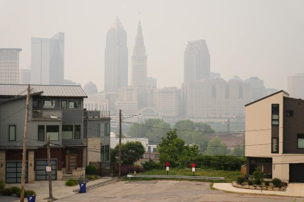 Smoke from Canadian wildfires blankets downtown Cleveland, forcing the postponement of a baseball game between the Pittsburgh Pirates and the Cleveland Guardians in Cleveland, Friday, July 17, 2026. (AP Photo/Sue Ogrocki)