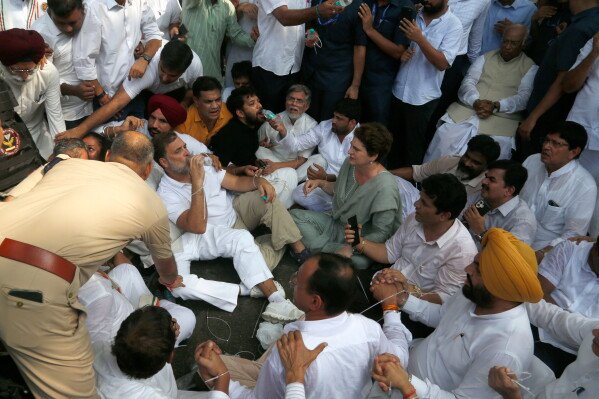 India's opposition Congress party leader Rahul Gandhi drinks water as he participates in a sit-in protest with his sister and lawmaker Priyanka Gandhi Vadra, center right, outside the residence of Prime Minister Narendra Modi in New Delhi, India, Tuesday, July 21, 2026. (AP Photo/Shekhar Yadav)