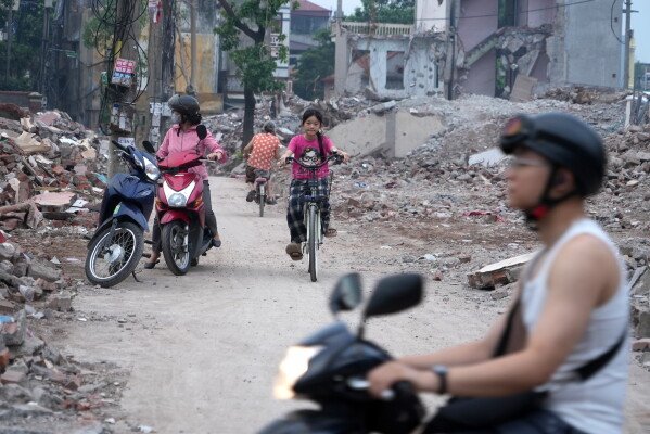People ride past a site being cleared for a new ring road in Hanoi, Vietnam, June 11, 2026. (AP Photo/Hau Dinh) 