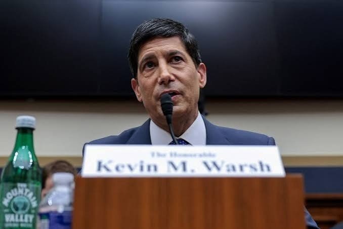 A man with black hair, wearing a business suit, sitting in front of a microphone at a US House of Representatives committee hearing.