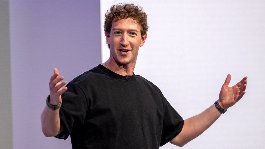 A technology executive stands on stage presenting new hardware during a company event.