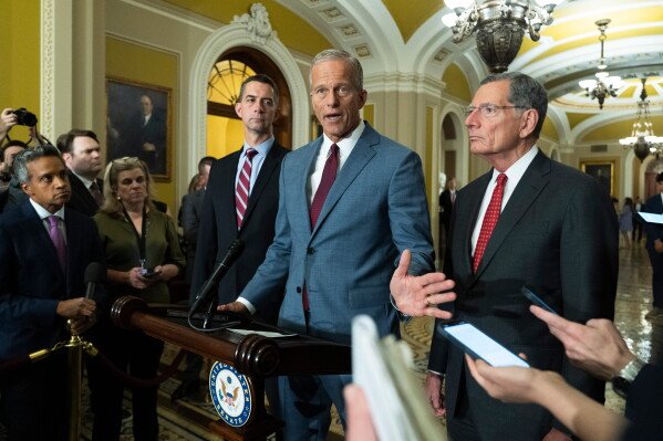 Senate Majority Leader John Thune, R-S.D., with Sen. Tom Cotton, R-Ark. left; and Sen. John Barasso, R-Wyo., speaks to reporters on Capitol Hill in Washington, Wednesday, July 29, 2026, in Washington. (AP Photo/Manuel Balce Ceneta)