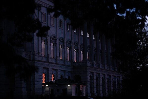 The sun sets behind the U.S. Capitol, Tuesday, July 28, 2026, in Washington. (AP Photo/Allison Robbert)
