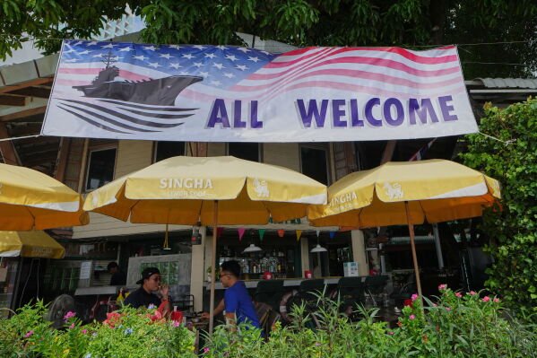 Customers of a restaurant sit under a banner in Pattaya, Thailand, on Sept. 1, 2026. (AP Photo/Sakchai Lalit)